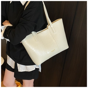 Detail of minimalist cream croc-effect tote bag showing premium embossed leather texture