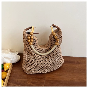 Close-up of woven shoulder bag with wooden beads and resin ring handle detail
