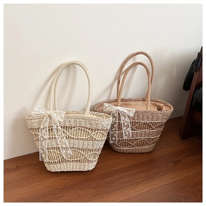 Detail of woven straw tote bags featuring delicate white lace bow accents in two colors