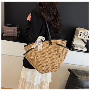 Détail du sac cabas en paille avec bordure en cuir noir et nœud en dentelle