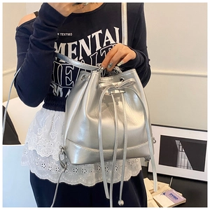 Detailed view of silver metallic drawstring bucket bag with elegant bow accent for women