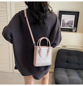 Détail des poignées en cuir rose et du motif jacquard blanc sur le sac bandoulière bohème