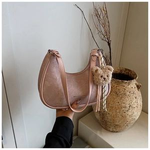 Pink half-moon underarm bag with cute plush bear charm and vintage aesthetic details