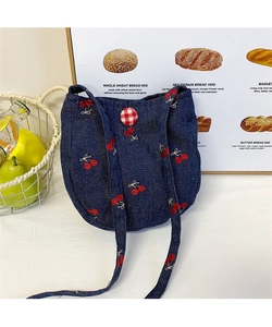 Détail du mini sac en jean bleu avec broderies cerises et bouton à carreaux rouges