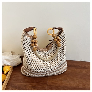 Detail of hand-woven tote bag with decorative large wooden beads and yellow ring buckles