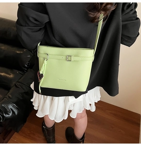 Detailed view of mint green lychee textured bucket bag with heart charm and strap buckle