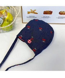 Vue détaillée du béguin pour bébé en denim bleu foncé avec cerises brodées et bouton