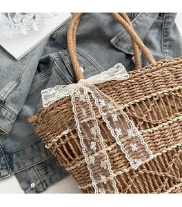 Detailed close-up of woven straw tote bag with white lace bow and fabric lining