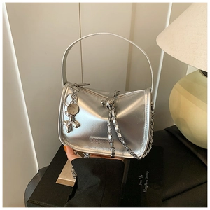 Silver metallic crossbody bag featuring a fashion plaque and balloon dog charm detail