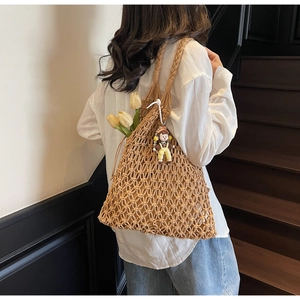 Detailed view of handmade khaki woven tote bag with a cartoon charm and tulip accent