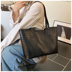 Chic black crocodile embossed tote bag shown on shoulder for large capacity visual