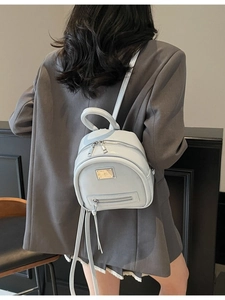 Fashionable light blue mini backpack with glossy finish and metal logo for stylish travel