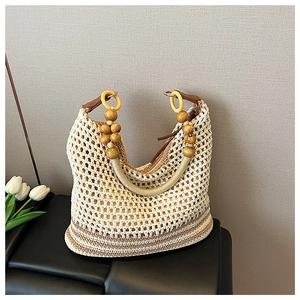 Close-up of woven beach tote featuring wooden beads and decorative rings on the handle