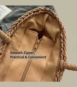 Detail view of woven straw tote bag with smooth zipper closure and fabric lining inside