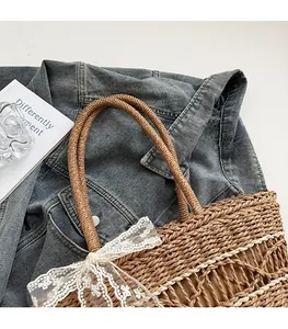 Detailed macro view of woven straw tote bag with delicate white lace bow and hollow pattern