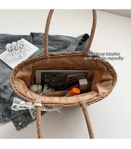 Flat lay of woven straw tote bag showing large capacity with tablet and accessories