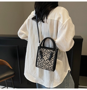 Détail d'un sac bandoulière bohème aux motifs géométriques et garniture cuir sur modèle