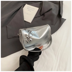 Detail of silver metallic handbag with fashion logo and balloon dog charm on grey suit