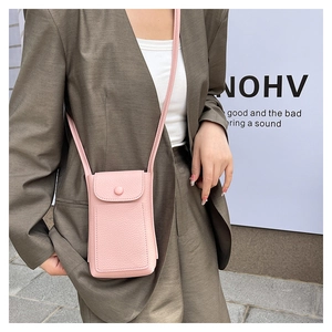 Detail of pink lychee textured leather mini crossbody bag with round decorative buckle