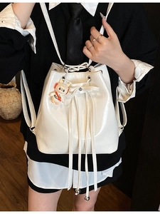 Trendy white faux leather bucket backpack for women with bow drawstring and cute bunny charm