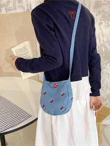 Petit sac rond en toile bleu clair avec broderie cerise et bouton décoratif à carreaux