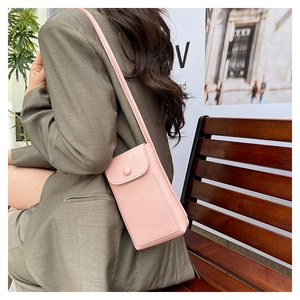 Pink litchi texture leather crossbody phone bag with snap closure worn by female model