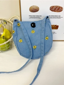 Sac bandoulière bleu clair avec broderie de fleurs jaunes et fermeture à bouton élégant