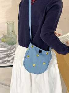 Sac bandoulière bleu clair brodé de fleurs assorti à une tenue décontractée chic