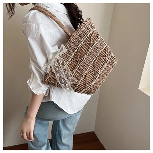 Macro shot of natural woven tote bag featuring delicate white lace bow details