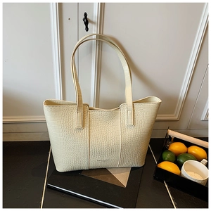 Detail of off-white crocodile embossed tote bag with Fashion & Bags logo and double handles