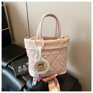 Detailed shot of pink quilted bucket bag featuring a Capybara charm and woven strap