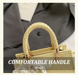 Detail of woven handle and pearl lace charm on a yellow minimalist tote bag