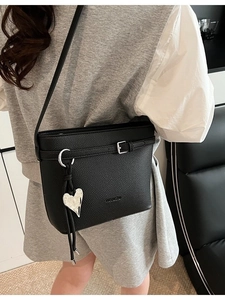 Black lychee leather bucket bag with silver heart pendant and shoulder strap