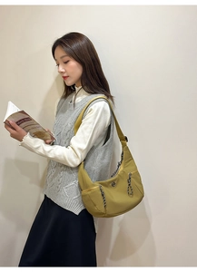 Sac bandoulière demi-lune vert olive porté par un mannequin avec bandoulière réglable chic