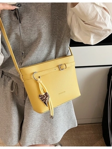 Bright yellow lychee pattern bucket bag with heart pendant and tassel details
