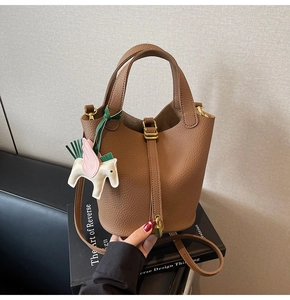 Detailed shot of litchi texture leather bucket bag with a small pony charm decoration