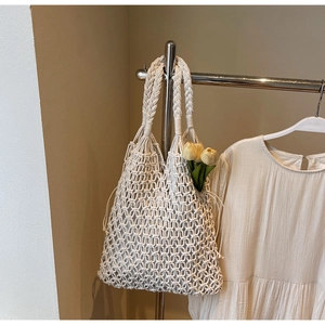 Detail of hollow woven tote bag in cream cotton rope featuring aesthetic tulip floral accents