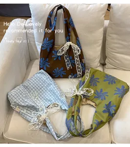 Detailed shot of three printed nylon crescent bags with delicate white lace ribbons
