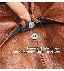 Macro detail of the magnetic buckle closure on a brown pebble leather tote shoulder bag