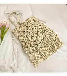 Close-up of handmade off-white macramé tote bag with intricate weave and long tassels