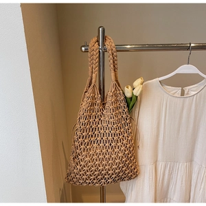 Close-up of a khaki handmade hollow woven tote bag with a white tulip accent detail