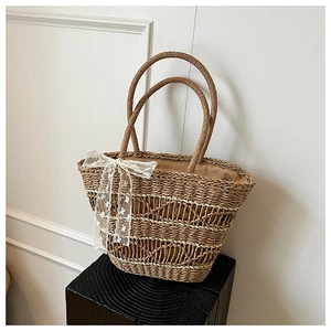 Detailed macro view of woven straw tote bag with elegant white lace bow charm