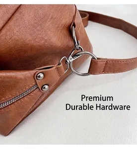 Detail of premium brown leather tote showing sturdy gunmetal hardware and litchi texture