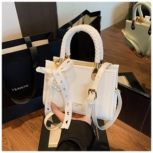 Detail of white PU leather crossbody bag with woven handle and pearl lace ribbon charm