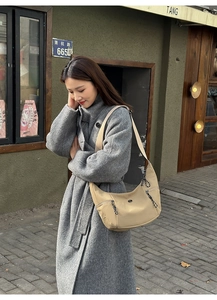 Détail d'un sac dumpling beige en nylon avec poches latérales et cordons de serrage tissés