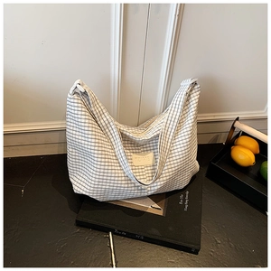 Detail of black and white checkered canvas tote bag with a leather logo on a display