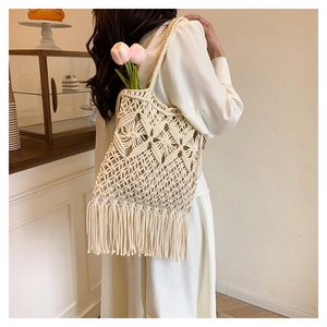 Detail of woven tote bag featuring geometric knit pattern and long fringe tassels