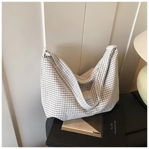 Detail of checkered canvas tote bag with woven wide shoulder strap and ZIMEI logo