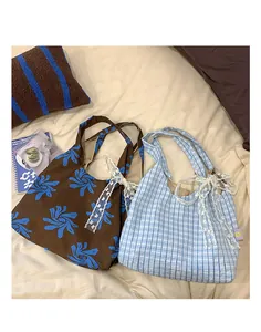 Detail showing printed nylon crescent bags with elegant white lace bows and floral pattern