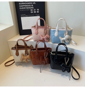 Détail de sacs seaux colorés avec motifs gaufrés et breloques en forme de petit chien